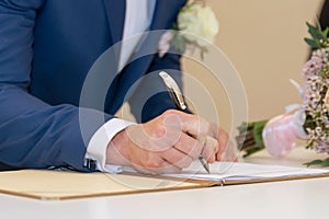Groom signing a wedding contract