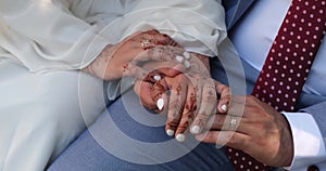 Groom stroking bride's hand. The bride and groom hold hands