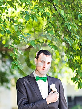 Groom in a suit holding buttonhole