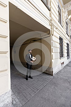 groom waiting a bride with flowers. man standing with flowers