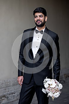 groom waiting a bride with flowers. man standing with flowers