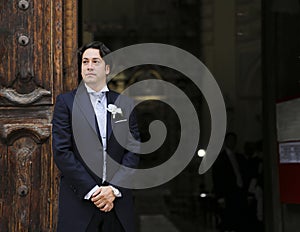 Groom waits for the bride at the church door