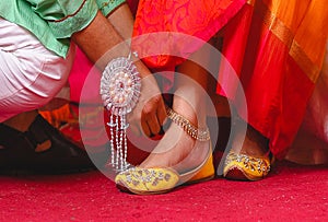   The groom is wearing anklets on the bride`s feet of wedding ceremony