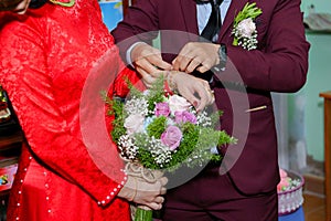 The groom is wearing a bracelet for the bride - Photo stock wedding Vietnam