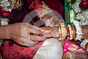 The groom wearing the bride a wedding ring on her finger