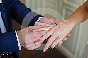 Groom wears bride a gold ring on her finger