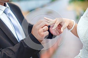 Groom wears bride a wedding ring on his finger. A couple betroth