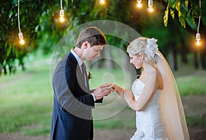 Groom wears the ring bride under the arch