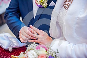 Groom wears the ring on the finger of the bride in the church.