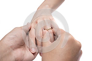 The groom wears the ring to bride on white background isolate