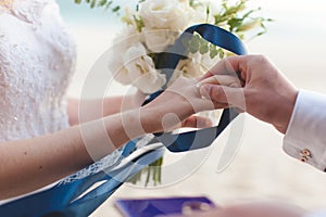 The groom wears a wedding ring on the finger of the bride close-up