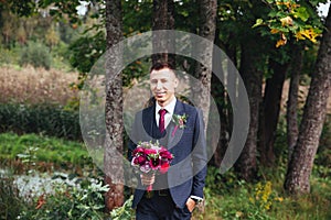 Groom at wedding tuxedo smiling and waiting for bride.