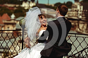 Groom whirls a bride on the roof with a great cityscape of Lviv