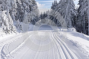 Groomed ski trail in sunny winter day on mountains road