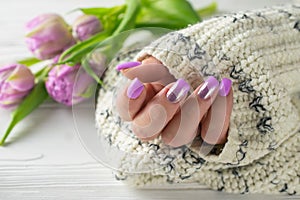 Groomed woman`s hands with purple nail varnish, manicure, hand care