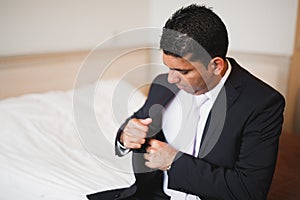 Grooms morning preparation. Handsome man getting dressed and preparing for the wedding