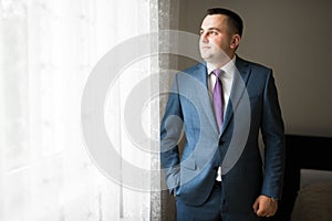 Grooms morning preparation. Handsome man getting dressed and preparing for the wedding