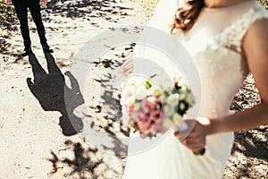 Grooms shadow nearly bride with wedding bouquet