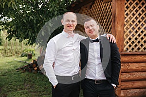 Groomsman spend time with groom at the backyard. Guys laugh and have fun photo