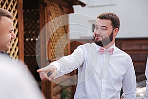 Groomsman spend time with groom at the backyard. Guys laugh and have fun photo