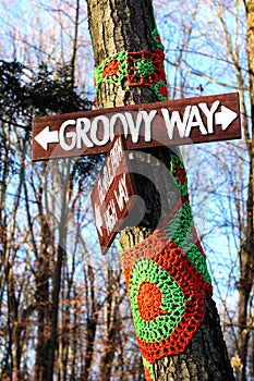 Groovy way sign on crochet trees in woods on a trail.