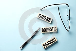 GROSS DOMESTIC PRODUCT text on wooden block ,blue background