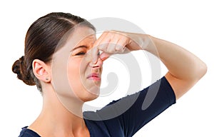 Gross. Studio shot of a young woman holding her nose isolated on white.