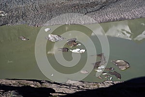 The peak of Grossglockner mountain is reflected in the water collected from the melting Pasterze glacier.