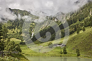 Grossglockner. Serpentine alpine road viewpoint. Green forest and waterfall. Austria
