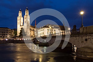 GrossmÃ¼nster church with bridge at night