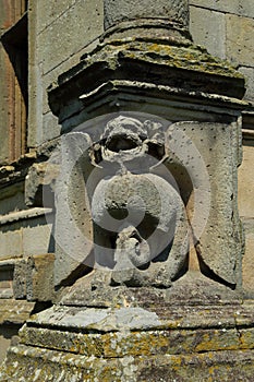 Grotesque gargoyle carving in stone on an old house