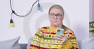 Grouch woman with phone in her hand is bored at party, family holiday, phubbing