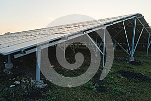 Ground based steel frame of large sustainable electrical power plant with rows of solar photovoltaic panels for