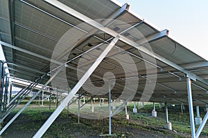 Ground based steel frame of large sustainable electrical power plant with rows of solar photovoltaic panels for