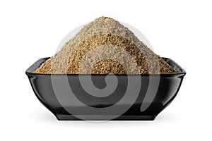 Ground black pepper in black bowl isolated on white. Front view