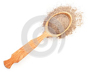 Ground black pepper in a wooden spoon on a white background. Top view