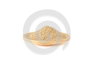 Ground cardamom powder on a mini wooden plate over a white background.