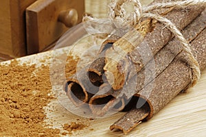Ground cinnamon and cinnamon bark on a wooden background