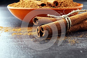 Ground cinnamon, cinnamon sticks, tied with jute rope and cinnamon powder in rustic style