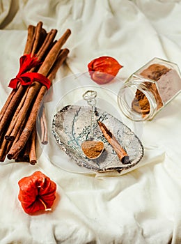 Ground cinnamon, cinnamon sticks, tied with red rope on old wood