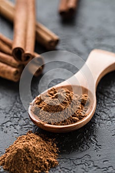 Ground cinnamon spice powder in wooden spoon