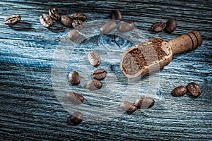 Ground coffee beans scoop on vintage wood board