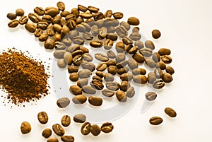 Ground coffee and beans on a white background. Coffee grounds and fried beans on a white table, close up. International Coffee Day