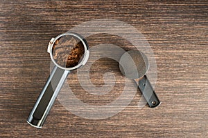 Ground coffee in brew unit on wooden counter
