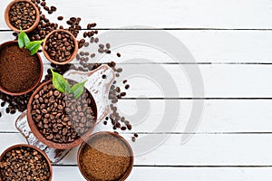 Ground coffee and coffee beans. On a white wooden background. Top view.