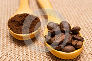 Ground coffee and grains with wooden spoon on jute canvas