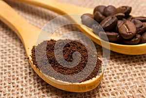 Ground coffee and grains with wooden spoon on jute canvas