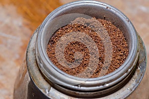 Ground coffee placed in the strainer of a traditional Italian macchinetta (coffee maker). photo