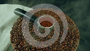 Ground coffee in portafilter on wooden board with coffee beans and dissipating steam. Freshly ground coffee in filter