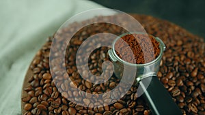 Ground coffee in portafilter on wooden board with coffee beans and dissipating steam. Freshly ground coffee in filter